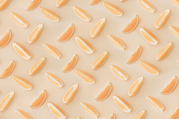 Fruit pattern of orange slices isolated on a light orange background. View from above.