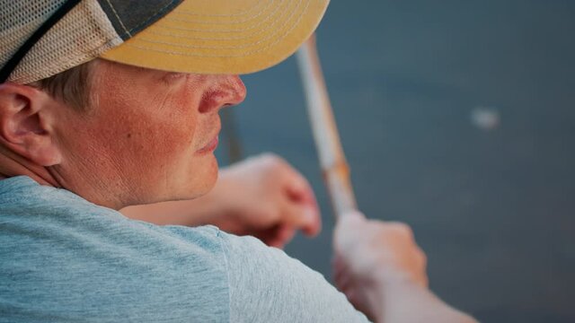 Bamboo rod fishing. Man fishing with retro bamboo fishing rod on the calm river