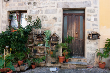 Fototapeta na wymiar Charming old house with wooden door and artisanal decor and plants in the patio