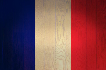 The flag of France on a grunge wooden background.