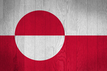 The flag of Greenland on a grunge wooden background.