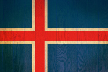 Fototapeta premium The flag of Iceland on a grunge wooden background.