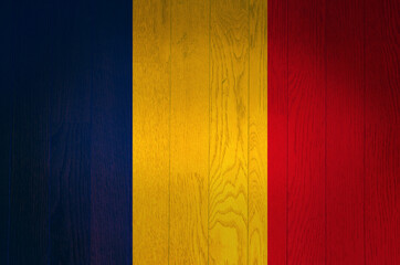 The flag of Romania on a grunge wooden background.