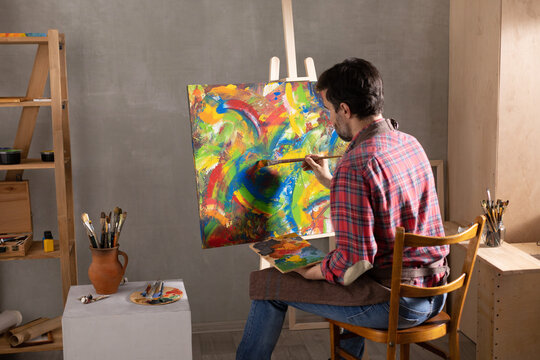 Male Artist Working On Painting. Man Artist Painter In Creative Studio