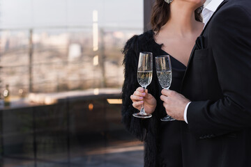 partial view of man and woman clinking glasses of champagne