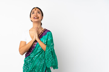 Young indian woman isolated on white background keeps palm together. Person asks for something