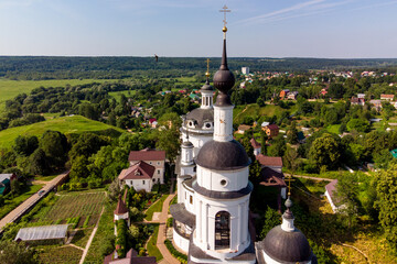 Fototapeta na wymiar Bell tower and cathedral of the Orthodox Chernoostrovsky monastery in Maloyaroslavets, Russia, beautiful aerial view. June 2021