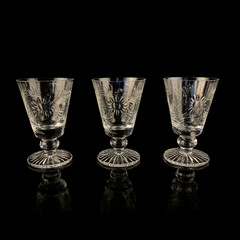 vintage set of crystal wine glasses on black isolated background. glass antique goblets