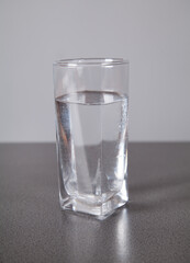 Water with glass, on gray background.
