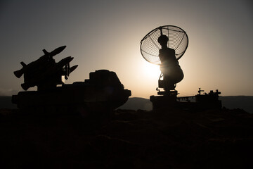 Creative artwork decoration. Silhouette of mobile air defence truck with radar antenna during...