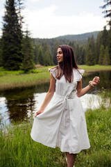 Pretty young woman in white dress outdoor near lake