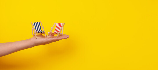 sunbeds on hand, tropical vacation, panoramic layout over yellow background