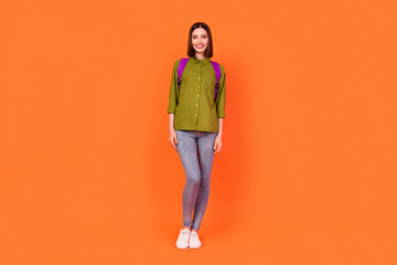 Fototapeta na wymiar Full size photo of nice brunette millennial lady wear bag shirt jeans isolated on orange color background