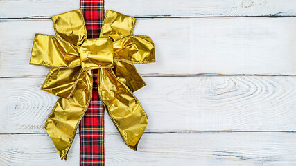 Bows on a banner, gold bows on a ribbon on a wooden light background banner with copy space