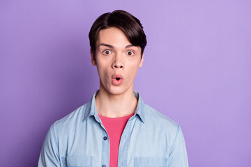 Photo of young guy amazed shocked surprised stupor fake novelty news isolated over violet color...