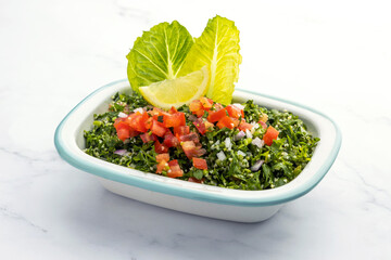 Traditional Arabic Salad Tabbouleh isolated on a marble backdrop