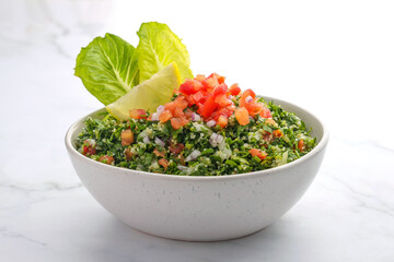 Traditional Arabic Salad Tabbouleh isolated on a marble backdrop