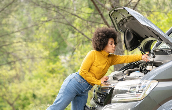 Black woman fixing van on a road trip