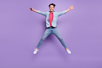Fototapeta na wymiar Full size photo of young excited guy happy positive smile jump up star isolated over purple color background