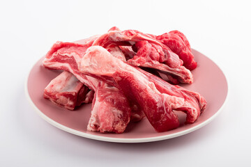 Raw lamb on the ribs. Pieces of red meat on white.