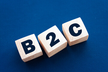 Motivational Words: B2C in 3d wooden alphabet letters on a blue background with copy space....