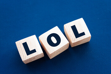 LOL - acronym from wooden blocks with letters, abbreviation LOL laugh out loud concept, blue...