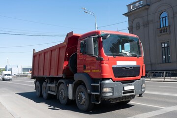 Red lorry at the city crossroads. Freight transport equipment in the city.