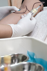 Nurse or lab technician drawing blood samples using a catheter and tube holder in the hospital or clinic. Focus on blood test tools on table