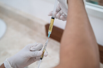 Close up of nurse or doctor hands preparing plasma syringe for PRP procedure - Platelet rich plasma rejuvenating treatment procedure