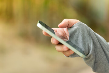 A Asian man hand hold or touch a Mobile Phone on his hand Smartphone in hand watching screen for message chat checking email using for People connecting Technology Communication Background