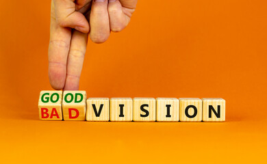 Good or bad vision symbol. Businessman turns cubes and changes words 'bad vision' to 'good vision'. Beautiful orange table, orange background, copy space. Business, good or bad vision concept.