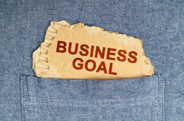 A piece of paper sticks out of his shirt pocket with the inscription - BUSINESS GOAL