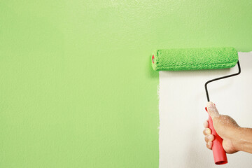 Roller Brush Painting, Worker painting on surface wall  Painting apartment, renovating with green...