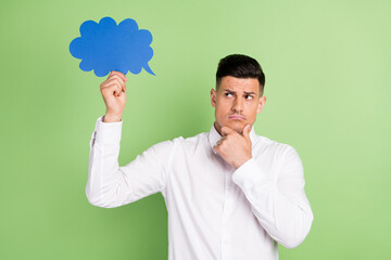Photo of sweet doubtful young gentleman wear white shirt arm chin looking mind cloud empty space isolated green color background