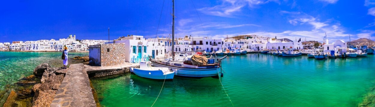 Serene Naoussa Paros. 17K drone panorama. White Cycladic village with fishing kaiki boats in turquoise water. Early morning mirror harbor. World Print quality. Greece summer coast landscape