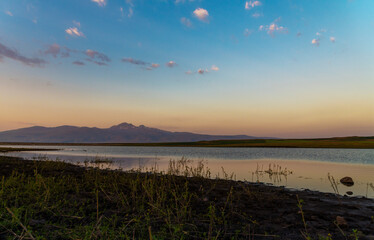 Beautiful summer landskepe on the sunrise, panoramic view on the lake and mountains.