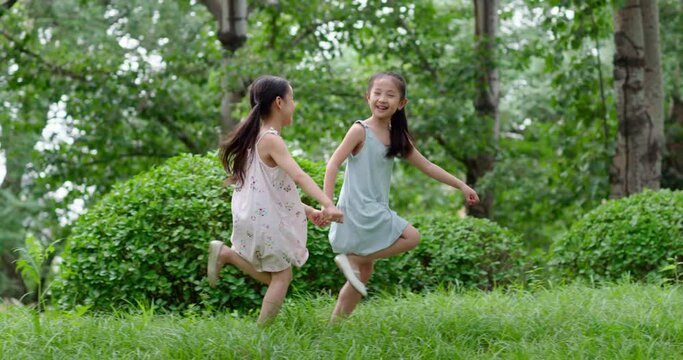 Two little girls playing on grass,4K