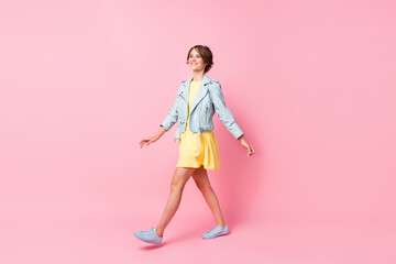 Profile photo of lovely positive lady walk wear yellow mini dress sneakers isolated pink color background