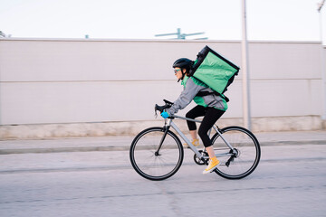 Delivery woman riding bicycle on street