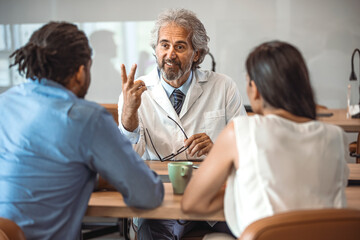 Obraz premium Cropped shot of a young couple having a consultation with their doctor. Shot of a doctor having a consultation with a couple in a clinic. Young couple during the consultations at clinic.