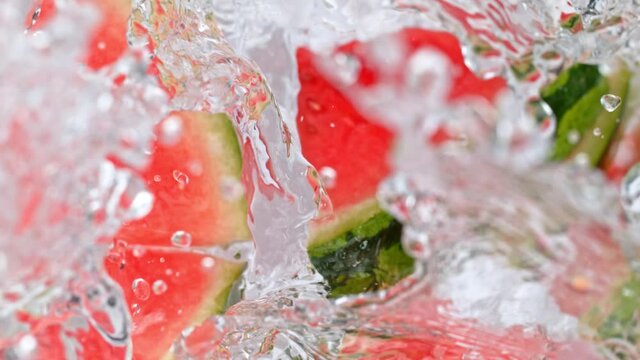Super Slow Motion Shot of Melon Slices Falling Into Water Whirl at 1000 fps.