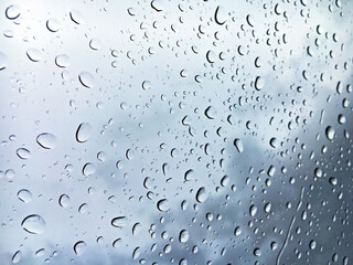Raindrops on the windowpane with a gray sky in the background out of focus - St. Gallen, Switzerland / Schweiz