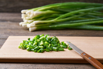 Fresh chopped green onion on a cutting board, selective focus.