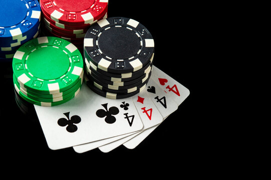 Poker game with four of kind combination. Chips and cards on the black table. Successful and maximum win. Free advertising space