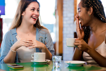 Fototapeta na wymiar Two female friends enjoying a cup of coffee together.