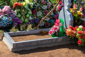 grave with flowers and funeral wreaths