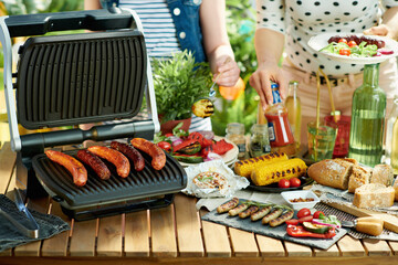 desk with electric grill and grilled sausages