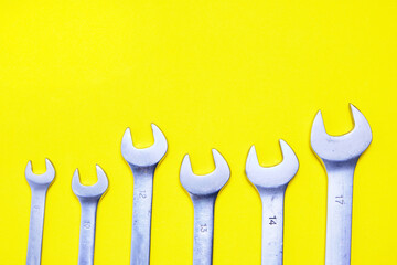 Set of wrenches on a yellow background.