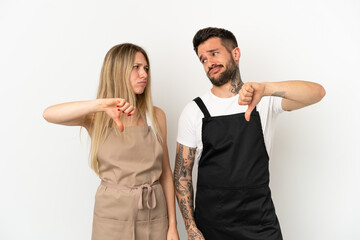 Restaurant waiter over isolated white background showing thumb down sign with negative expression