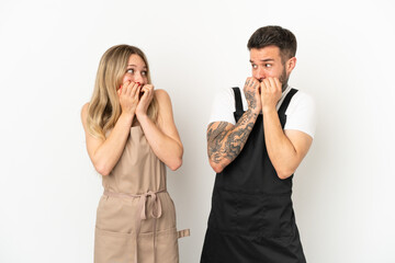 Restaurant waiter over isolated white background is a little bit nervous and scared putting hands to mouth